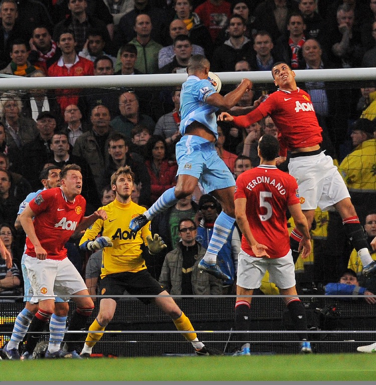 Vincent Kompany rises above the Manchester United defenders to put Manchester City ahead. (Andrew Yates/AFP/Getty Images)