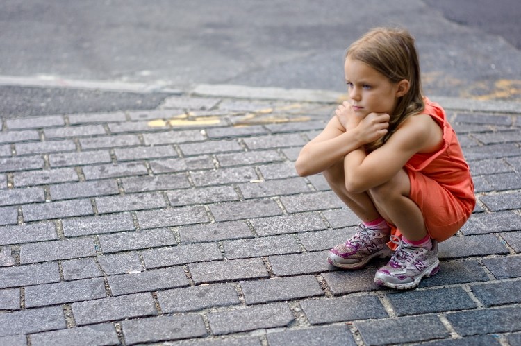 A young girl is lost in thought as she crouches on the street. Dr. Charles A. Williams III, assistant clinical professor at Drexel University's School of Education, says it is important that parents instill self-esteem and confidence in their children.(Kozzi Images)