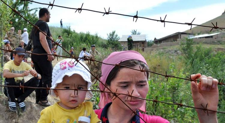 An ethnic Uzbek mother holds her daughter as they wait at the Kyrgyz-Uzbek border outside a village of Suratash on June 14, 2010. (Viktor Drachev/AFP/Getty Images)