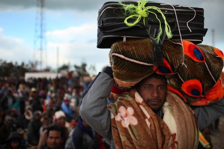 FLEEING THE VIOLENCE: Bangladeshi men wait after entering Tunisia to be taken to a transit camp on March 1, in Ras Jdir, Tunisia. As fighting continues in and around the Libyan capital of Tripoli, thousands of guest workers from Egypt, Tunisia and other countries are fleeing to the border of Tunisia to escape the violence. (Spencer Platt/Getty Images) FLEEING THE VIOLENCE: Bangladeshi men wait after entering Tunisia to be taken to a transit camp on March 1, in Ras Jdir, Tunisia. As fighting continues in and around the Libyan capital of Tripoli, thousands of guest workers from Egypt, Tunisia and other countries are fleeing to the border of Tunisia to escape the violence. (Spencer Platt/Getty Images)