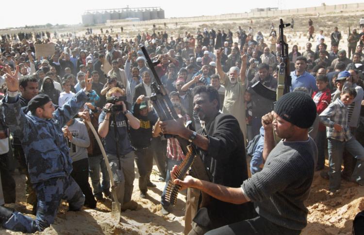 ANTI-GOVERNMENT FORCES: Rebel fighters shoot into the air during a funeral for slain comrades on March 3, in Ajdabiya, Libya. At least 14 people died reportedly in fighting in Brega, Wednesday when rebels fought back an offensive from troops loyal to Pres (John Moore/Getty Images)