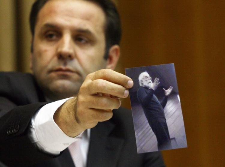 Serbian Minister Rasim Ljajic holds a photo of war-crimes suspect Radovan Karadzic during a press conference in Belgrade on July 22, 2008. On Dec. 29, Ljajic stepped down as the coordinator of the Action Team coordinating with the International Criminal Tribunal for Former Yugoslavia over failing to capture a key war-criminal suspect. (Goran Sivacki/AFP/Getty Images )