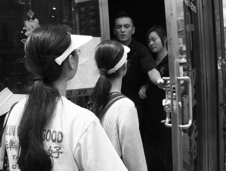 NO JOY: Falun Gong practitioners listen to a waiter after being forced to leave Lucky Joy Restaurant in  Flushing last year. (Evan Mantyk/The Epoch Times)