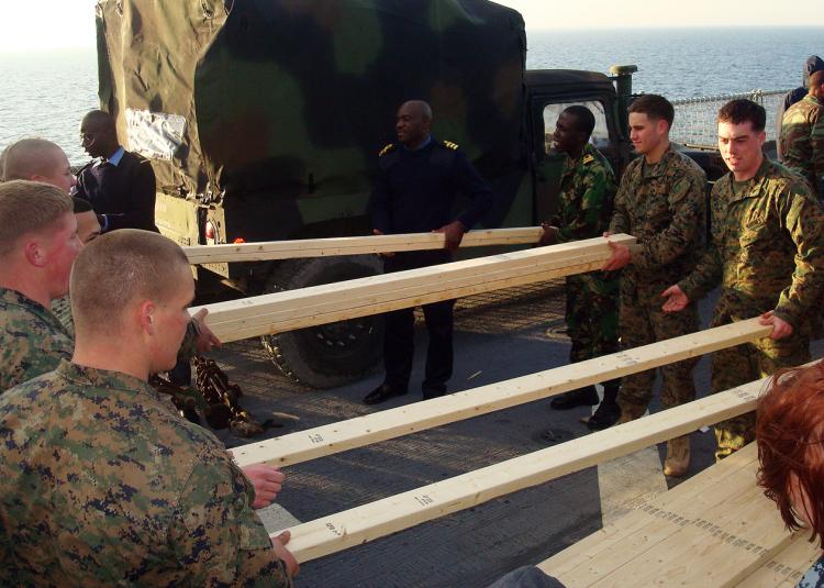 Members of Africa Partnership Station West and U.S. Marines move lumber on the flight deck of USS Gunston Hall. Gunston Hall was diverted from her scheduled deployment to Africa to Haiti to assist in Operation Unified Response. (Navy Visual News Service/Shawn Mestres)