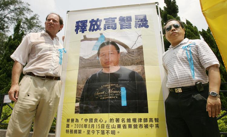 Edward McMillan-Scott (L) Vice President, European Parliament poses with Democracy Legislator Albert Ho next to a portrait of mainland Chinese jailed human rights lawyer Gao Zhisheng in Hong Kong, 26 August 2006. (Mike Clarke/AFP/Getty Images)