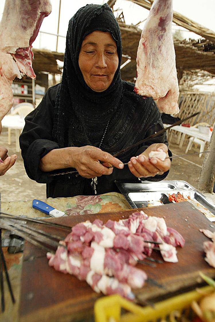 An Iraqi woman sells meat at her street stall in Baghdad. Micro lending attempts to help small entrepreneurs in developing countries establish a foothold and rise above poverty.  (Ali Yussef/AFP/Getty Images )