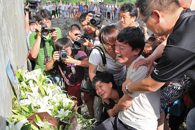 WATCHFUL: Family members grieving the victims that died in the July 23 high-speed train crash at the accident scene in Shuangyu, near Wenzhou, in Zhejiang Province. One of China's official newspapers accused authorities of 'arrogance' in their handling of (The Epoch Times Photo Archive)