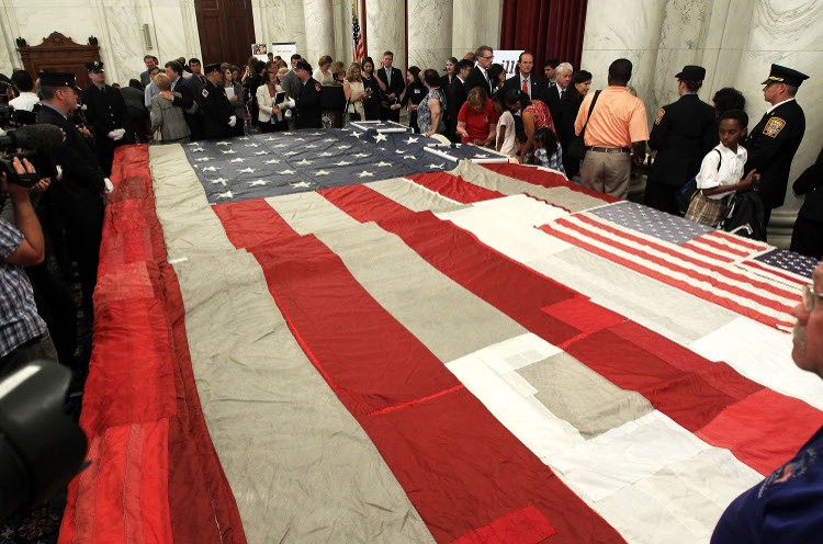 Family members of September 11th victims mend the National 9/11 flag, to commemorate the ten year anniversary of the terrorist attack. (Alex Wong/Getty Images)