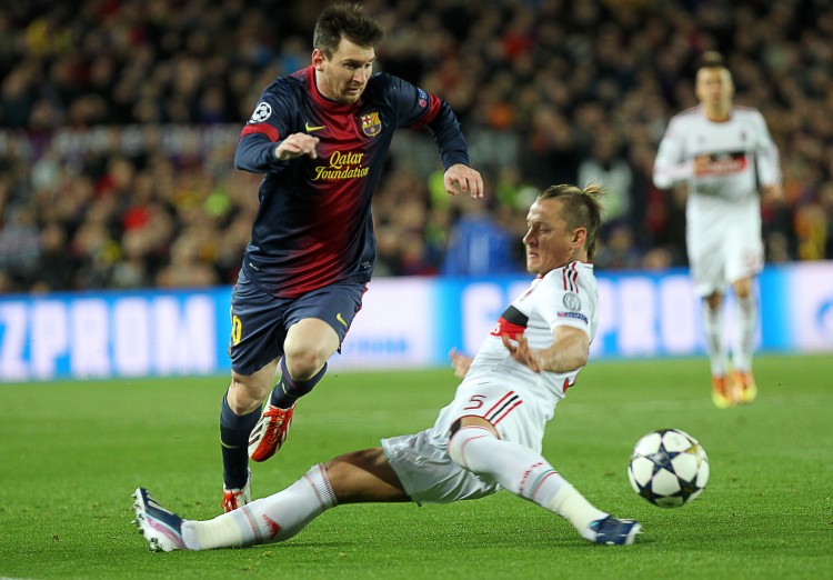 Barcelona's Lionel Messi moves past AC Milan defender Philippe Mexes in Champions League action in Barcelona on Mar. 12, 2013. (Quique Garcia/AFP/Getty Images) 