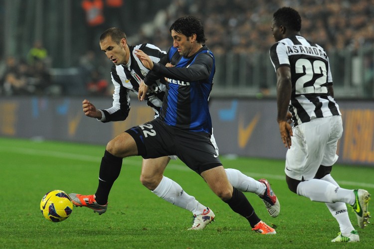 Inter Milan's Diego Milito (center) fends off Juventus player Giorgio Chiellini (L) in Serie A action taking place in Turin on Saturday, Nov. 3, 2012. Milito scored twice and Inter Milan ended Juventus' 49-match unbeaten streak in Serie A. (Valerio Pennicino/Getty Images)