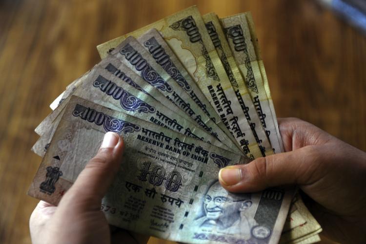 Indian rupee notes at a bank in Kolkata on July 15. India unveiled Thursday a symbol for its rupee currency that it hopes will become as globally recognized as signs for the dollar, the yen, the pound and the euro.  (Deshakalan Chowdhury/Getty Images)