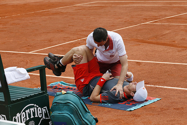 Andy Murray's trainer tries to unkink the fourth-ranked player's spasming lower back during his second-round French Open match against Finland's Jarkko Nieminen. (Patrick Kovarik/AFP/GettyImages)