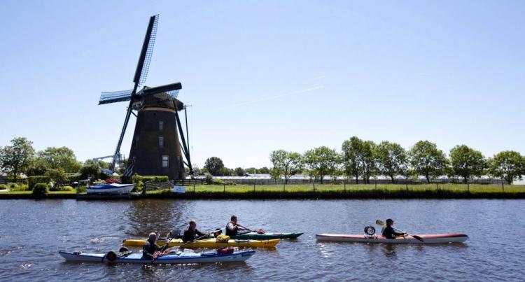 Canoes pass windmills in Weteringbrug, Western Netherlands, on May 29, 2009. A U.N. Report wrongly stated 55 percent of the Netherlands lies below sea level. (Nils van Houts/AFP/Getty Images)