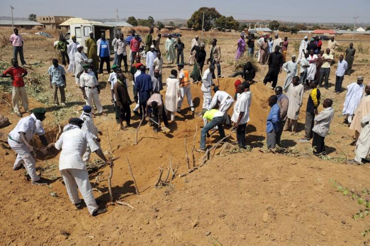Workers close mass graves where dozens of people killed during the violent religious clashes were buried early on January 23, in Jos, Plateau State. Over 200 people are feared dead after clashes erupted outside of the central city over religious differences between Christians and Muslims Sunday morning. (Pius Utomi Ekpei/AFP/Getty Images)