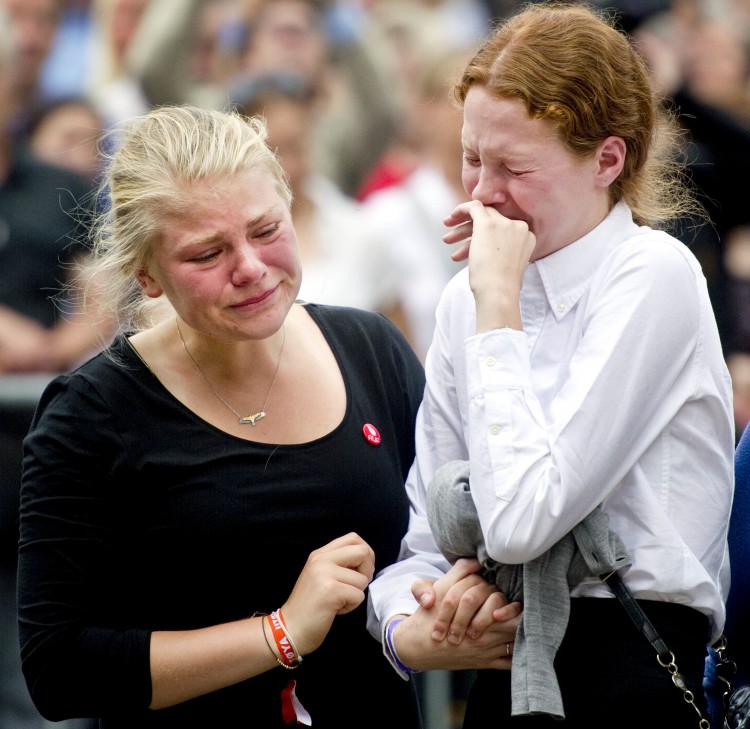 Two young women mourn during a gathering on Sunday in Oslo to pay tribute to the victims of Friday's twin attacks. At least 93 people died in the bombing of Norway's main government building and the shooting spree at the summer camp for the Labor Party's youth wing. (Odd Andersen/Getty Images)