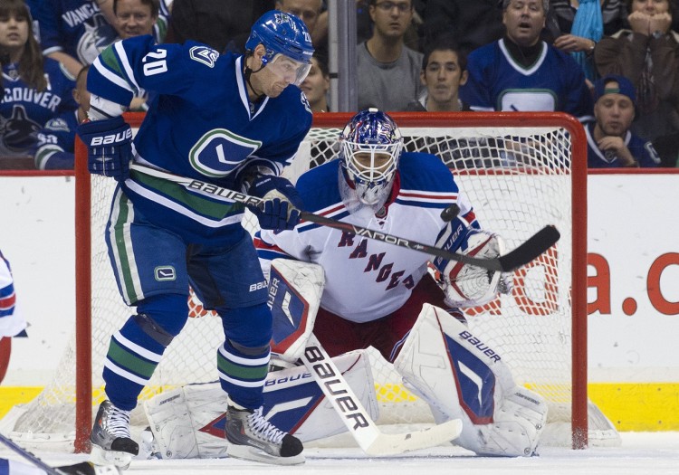 Vancouver's Chris Higgins tries to score on New York's Henrik Lundqvist in a game played on Oct. 18, 2011, in Vancouver. The Canucks and Rangers were two of the higher-spending yet more profitable NHL teams last year.  (Rich Lam/Getty Images)