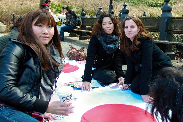 HAND-IN-HAND: Volunteers for the Hand-in-Hand Project for Japan collect funds for earthquake relief, and offer New Yorkers strolling through Central Park a chance to sign a Japanese flag with a message of hope to be sent to the devastated region. (Tara MacIsaac/The Epoch Times)