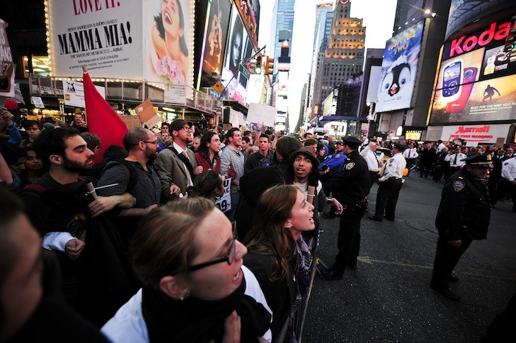 Occupy Wall Street participants link arms to try to push trough police barricade on Times Square in New York on Oct. 15. (Emmanuel Dunand/Getty Images)
