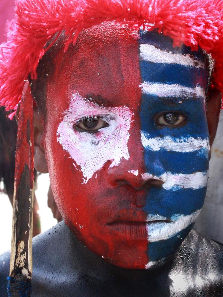 A Papuan tribesman's face is painted with the color of the banned separatist flag during a rally in Jayapura on July 8, urging the provincial Parliament to demand a referendum on self-determination.