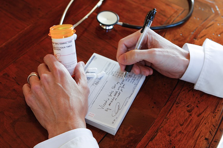  A doctor in California fills out a prescription form for Vicodin medication on Dec. 13, 2012. (Maria Daly Centurion/The Epoch Times)