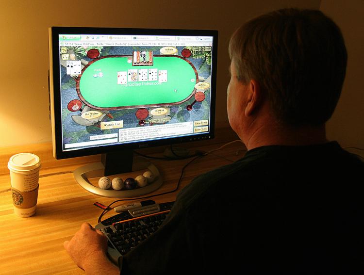ILLEGAL? In a file photo, a man plays online poker on his computer connected to an internet gaming site from his home in Manassas, Va. Three of the biggest online poker websites were shut down late last week by U.S. authorities. (Karen Bleier/AFP/Getty Images)