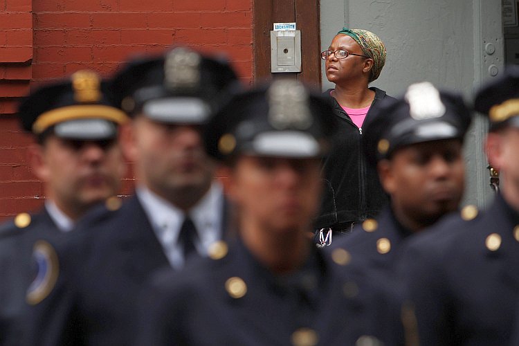 A woman watches as New York City police officers line up
