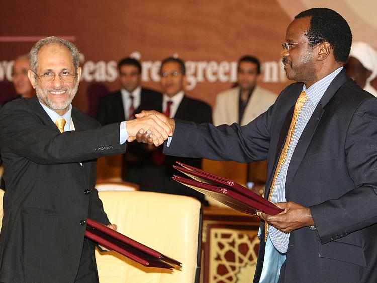 Ghazi Salahuddin (L), adviser to Sudan's President Omar Hassan al-Bashir, and Al-Tijani Al-Sissi of the Liberation and Justice Movement (LJM) shake hands after signing a ceasefire agreement, in Doha on March 18, 2010. (Karim Jaafar/AFP/Getty Images)