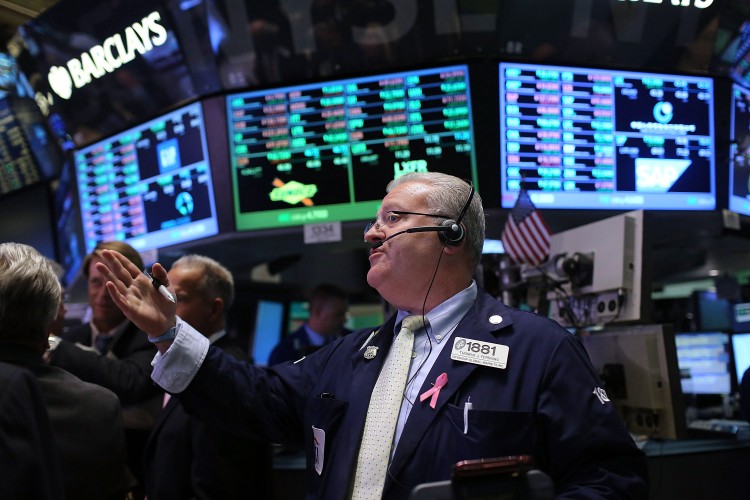 Traders work on the floor of the New York Stock Exchange during afternoon trading on Oct. 4. Third-quarter earnings season kicks off today with Alcoa, but S&P 500 companies are poised to register their first declines in earnings since 2009. (Spencer Platt/Getty Images)