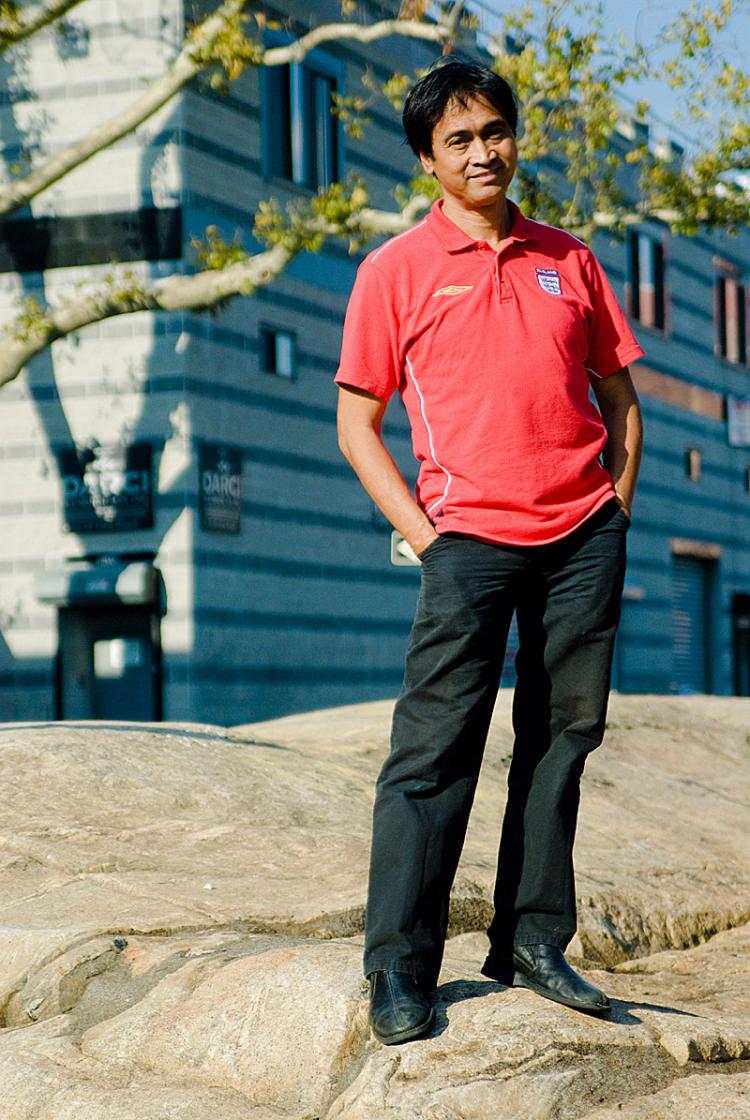 ROCK STAR: Emanuel Fuentebella standing on the LIC Rock that was made into a park through his efforts. Behind him is also a tree that he saved from destruction.  (Joshua Philipp/The Epoch Times)