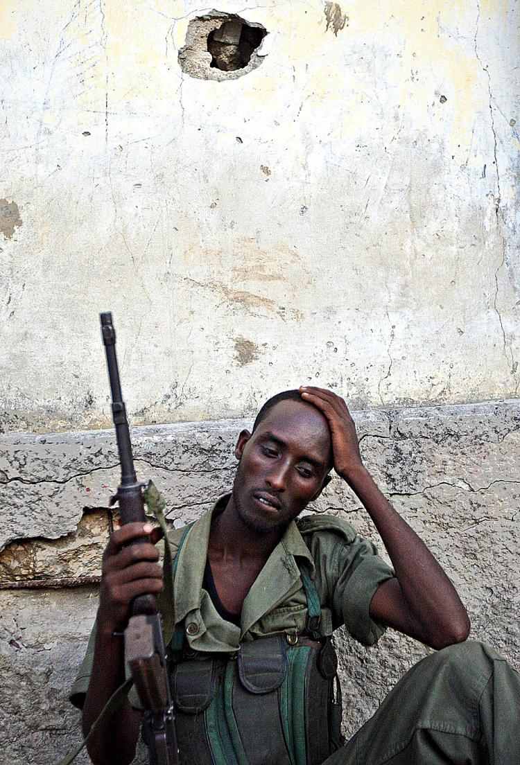 A woman who fled the recent fighting in Mogadishu prepares breakfast next to a makeshift hut at internally displaced camp on the outskirts of Mogadishu. (Mohamed Dahir/AFP/Getty Images)