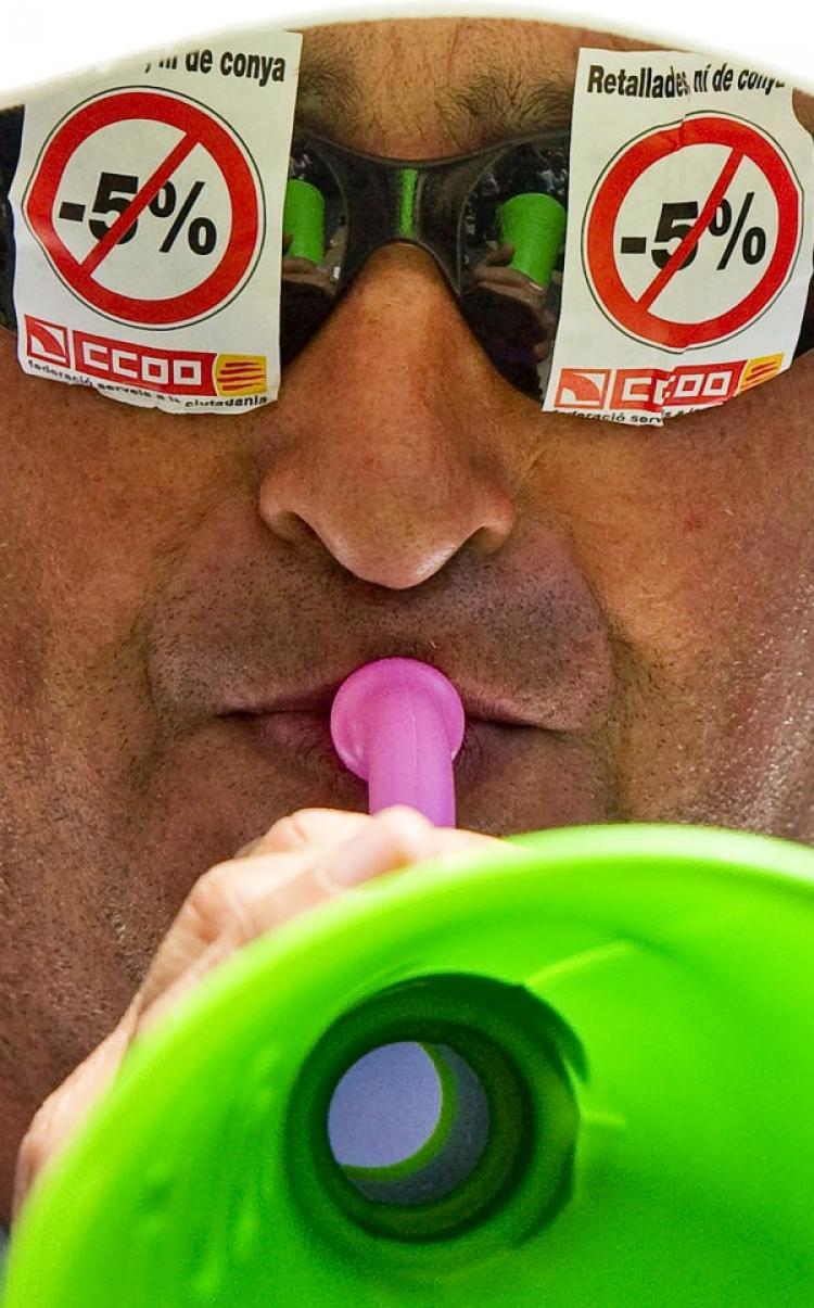 A man protests the government's proposed five percent cut in public sector wages during a worker strike in Barcelona on June 8. (Josep Lago/AFP/Getty Images)