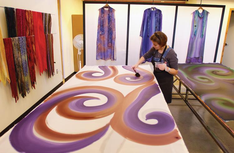 An artist hand-paints silk at Railspur Alley, considered the heart of the Granville Island artistic community. Since its redevelopment in the 1970s, Granville Island has been a haven for the arts.  (CMHC-Granville Island)