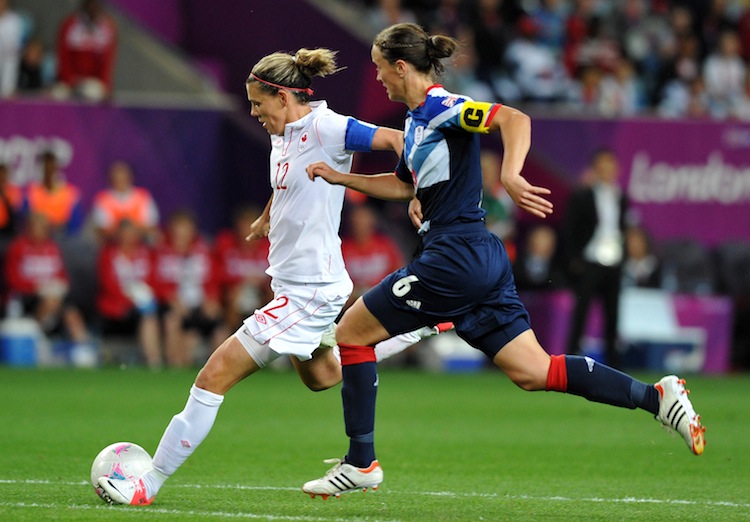 Canada's Christine Sinclair (L) gets past Great Britain's Casey Stoney in Olympic women's soccer quarterfinal action on Friday. (Paul Ellis/AFP/GettyImages)