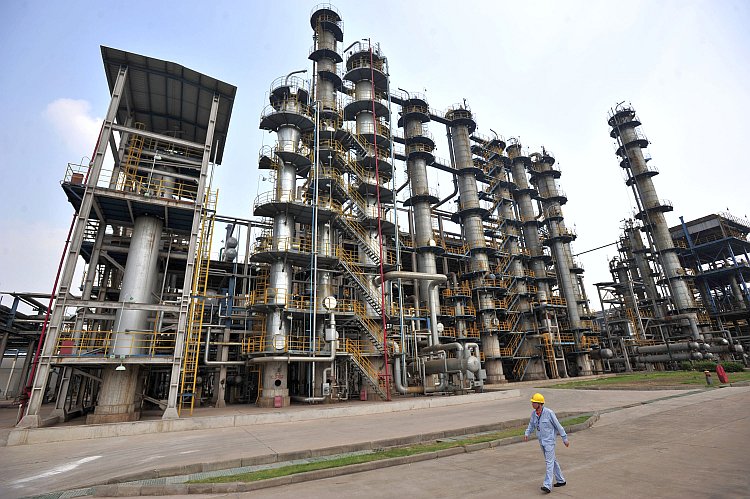 A Chinese worker walks by a Sinopec oil refinery