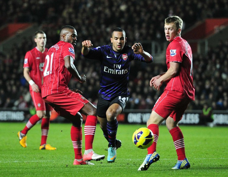 Southampton players Guilherme Do Prado (L) and James Ward-Prowse (R) contest Arsenal's Theo Walcott for the ball at St. Mary's Stadium in Southampton, England on Jan. 1, 2013. (Glyn Kirk/AFP/Getty Images) 