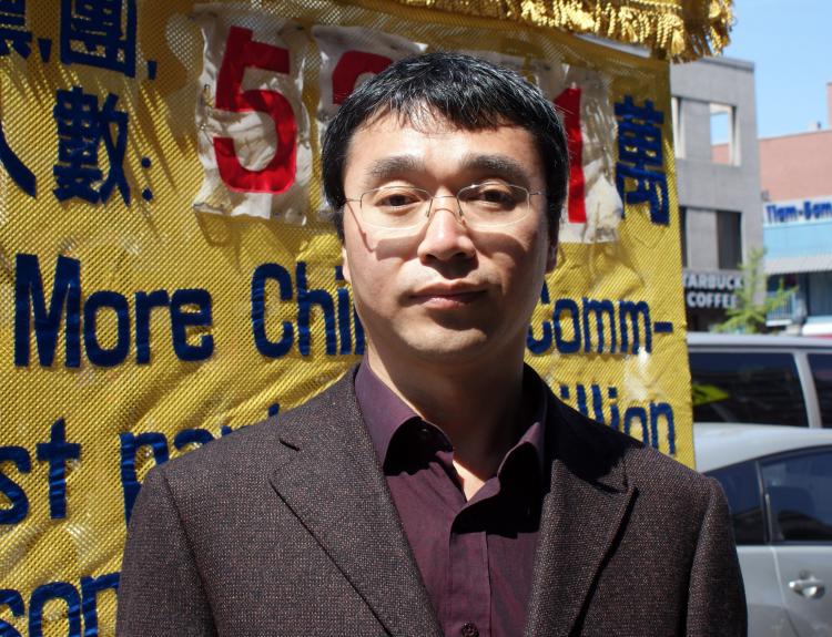 Sun Yanjun stands beside a Quit the CCP booth in Flushing, New York, April 26, 2009. (Charlotte Cuthbertson/The Epoch Times)