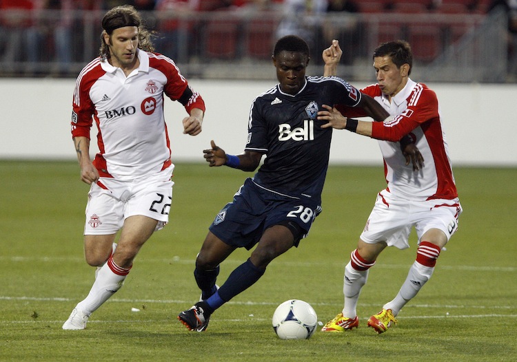 Toronto FC's Torsten Frings (L) and Eric Avila (R) put some heat on Vancouver Whitecaps Gershon Koffie at BMO Field in Toronto Wednesday night. Toronto defeated Vancouver 1-0 to win the Voyageurs Cup for the fourth straight year and a place in CONCACAF Champions League. (Abelimages/Getty Images)