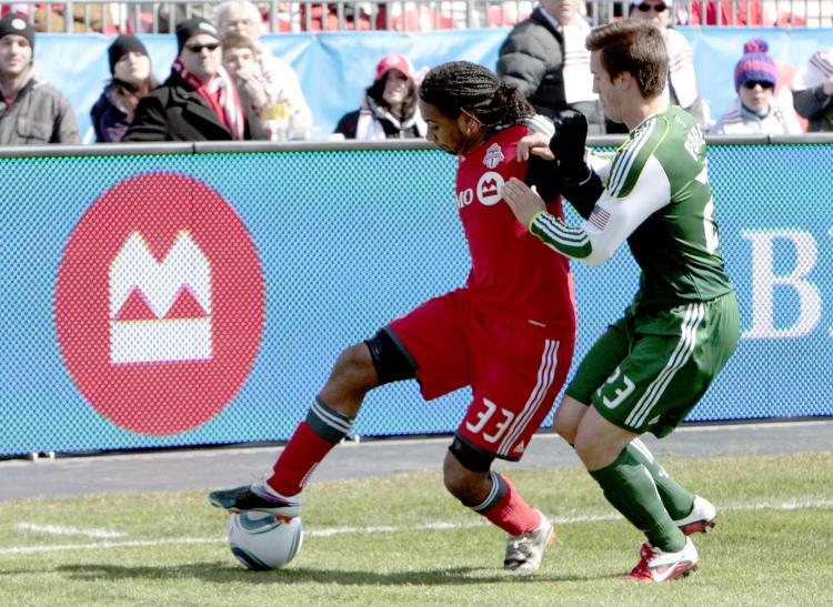 Toronto FC's Javier Martina (L) holds off Portland's Steve Purdy. (Abelimages/Getty Images)