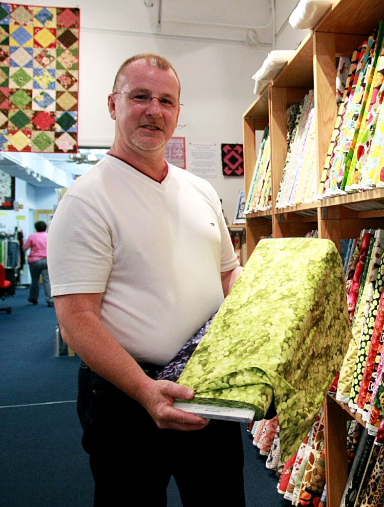 FABRIC FUN: Charles Johns displaying fabrics in The City Quilter shop, where he teaches quilting classes. (Gidon Belmaker/The Epoch Times)