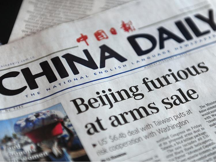 TEMPER TANTRUM: A copy of China's state-run English-language China Daily with a headline regarding U.S. arms sales to Taiwan, in Beijing on Feb. 1. China's state media accused Washington of 'arrogance' and 'double standards'' in going ahead with arms sales to Taiwan, saying Beijing's threat to penalize U.S. companies over the deal was very real.  (Frederic J. Brown/AFP/Getty Images)