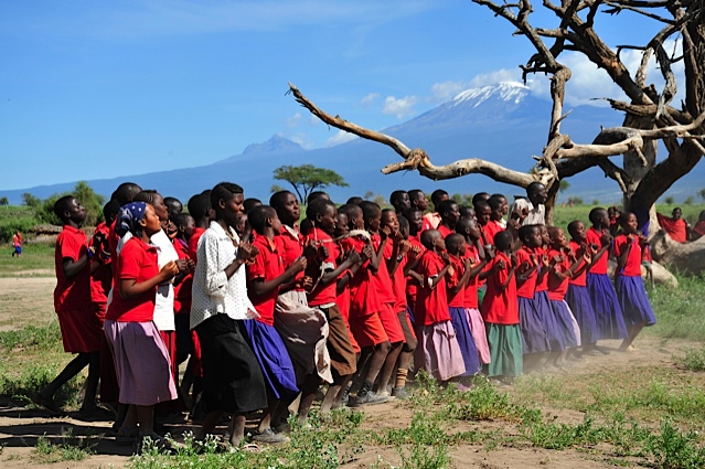 Students from Esiteti Primary School sing with Mount Kilimanjaro in the background. (Courtesy of ASK)