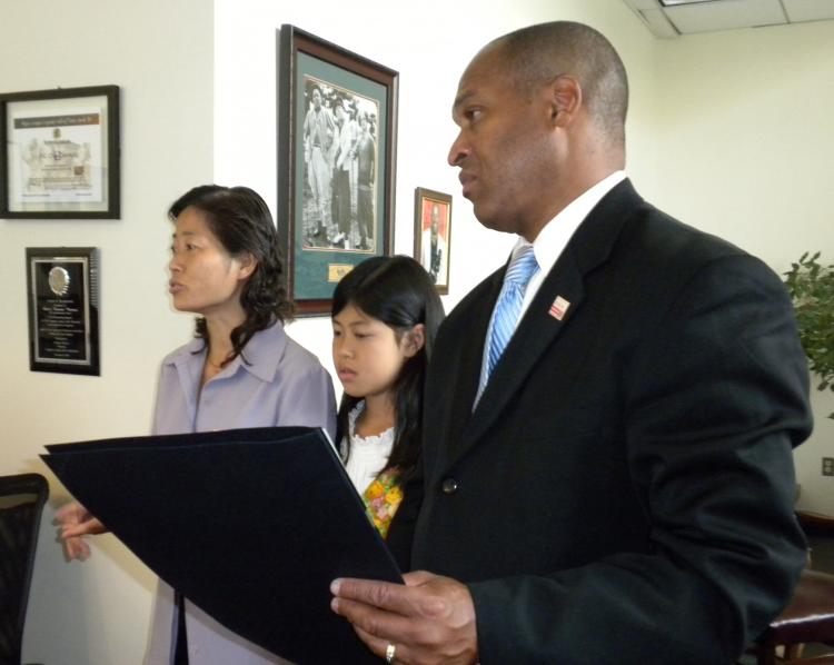 OPPORTUNITY TO TEACH: DC Councilman Harry Thomas, Jr. welcomes Falun Dafa persecution victims Jane Dai and her daughter Fadu, July 20, and introduces them to summer interns. (Angela Lee/The Epoch Times)