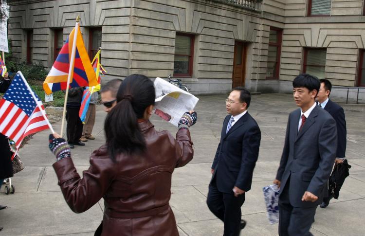 Chinese officials walk toward Tibetan protesters after visiting Portland City Hall on March 8.  (Jampa Lhatsang/www.TibetanPrayerFlag.com)