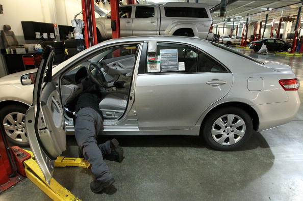 Toyota service technician Tungyio Saelee performs a recall repair on an accelerator pedal from a brand new Toyota Corolla. (Photo by Justin Sullivan/Getty Images)