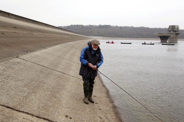 A fisherman casts his line into the water. (Justin Tallis/AFP/Getty Images)