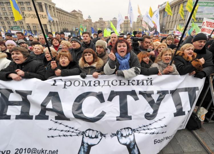 People hold a banner reading 'civil attack' during a rally against a controversial tax reform on Independence Square, in Kyiv, on Nov. 22. As President Viktor Yanukovych met with EU officials to talk about Ukraine's bid to join the EU in Brussels, he is facing increasing problems at home over his new tax code due to enter into force on Jan. 1. (Sergei Supinsky/AFP/Getty Images)