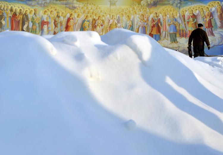A man walks in snow in front of frescos of Mykhaylo Gold Domes Cathedral in Kyiv on Dec. 21, 2009, after heavy snow fall in Ukrainian capital. Heavy snow throughout the winter in Ukraine is raising fears that there will be severe flooding with warmer weather. (Sergei Supinsky/AFP/Getty Images)