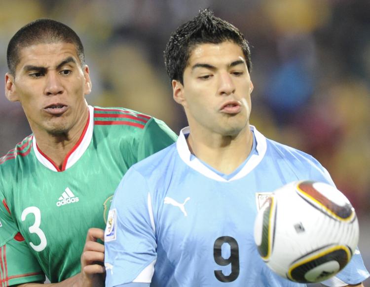 Uruguay's Luis Suarez holds off Mexico's Carlos Salcido in the Group A finale in Rustenberg on Tuesday.