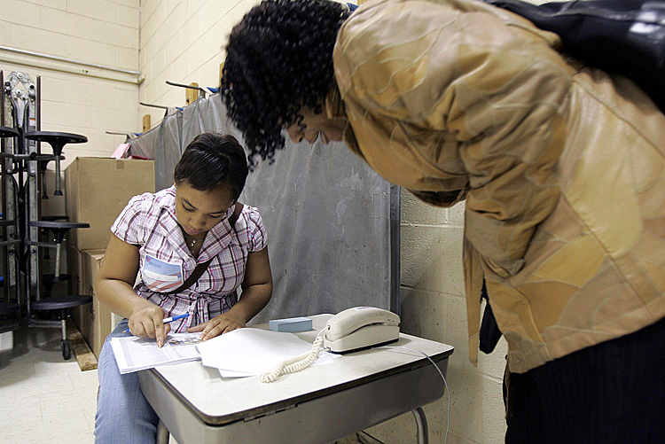 A poll volunteer (L) checks the ID of a voter during the last presidential election Nov. 4, 2008, in Cleveland, Ohio. A Commonwealth Court judge in neighboring Pennsylvania has ruled the state's new photo ID requirement should not be enforced for the upcoming November elections.(J.D. Pooley/Getty Images)