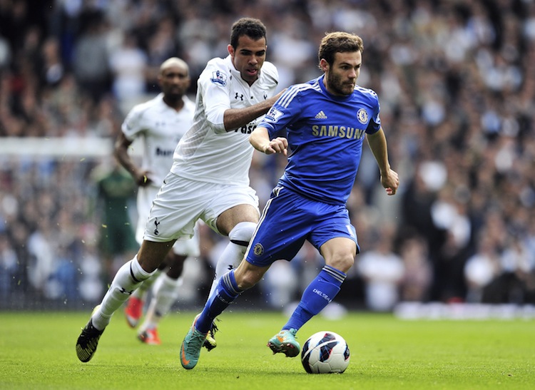 Juan Mata of Chelsea drives pasat Tottenham's Sandro in Saturday's English Premier League London derby match. Mata scored two goals and set up another in a convincing Chelsea win. (Glyn Kirk/AFP/Getty Images)